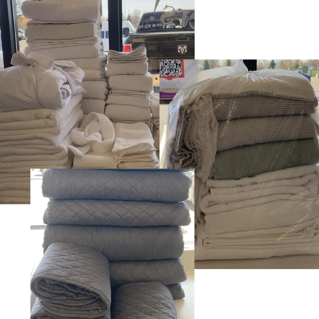 Neatly folded laundry and bedding in plastic bags, Sprinkle Laundry drop-off wash and fold service.